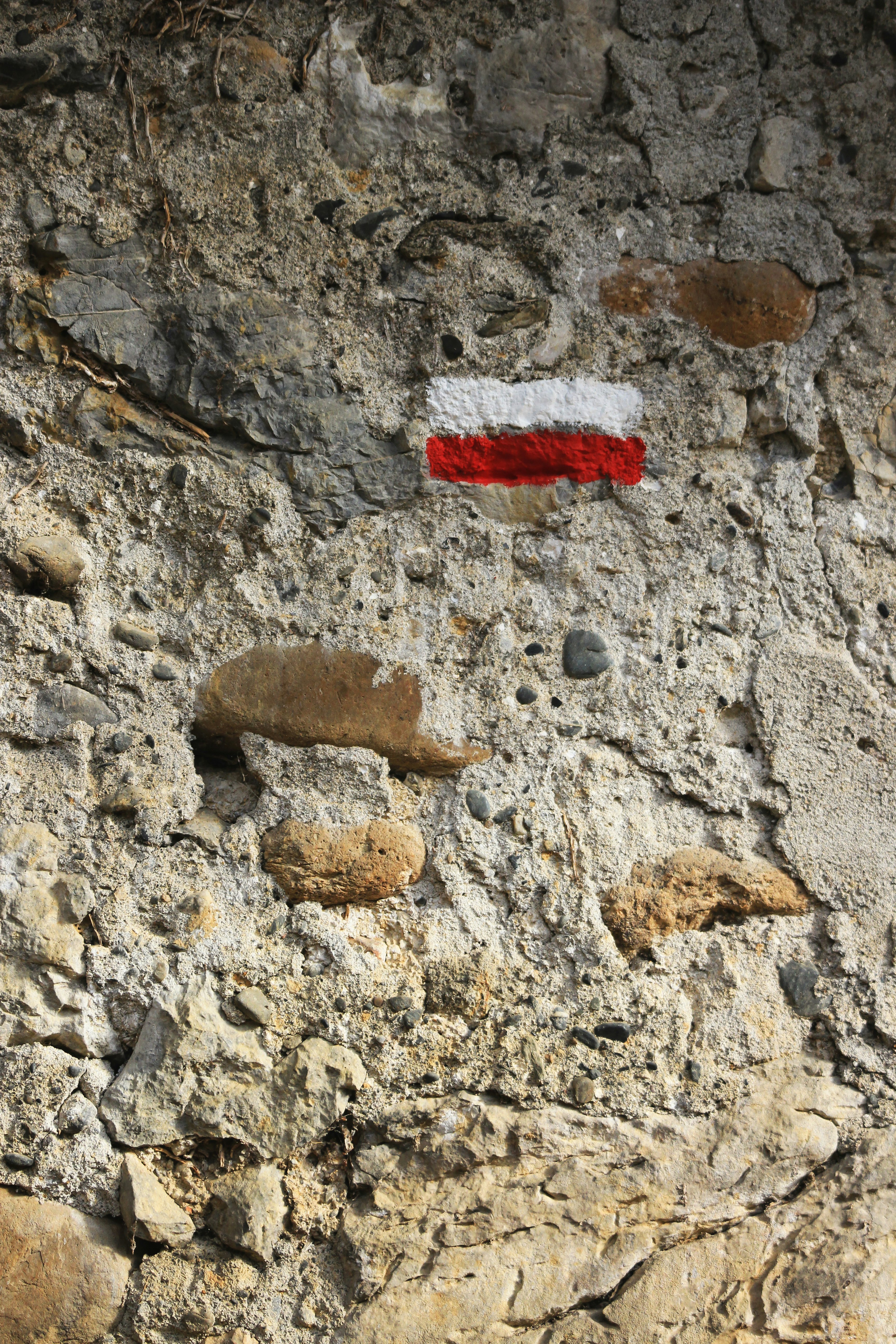 red and white striped paint on stone wall